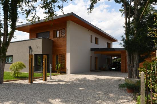 Maison moderne avec bardage en bois et grandes fenêtres.