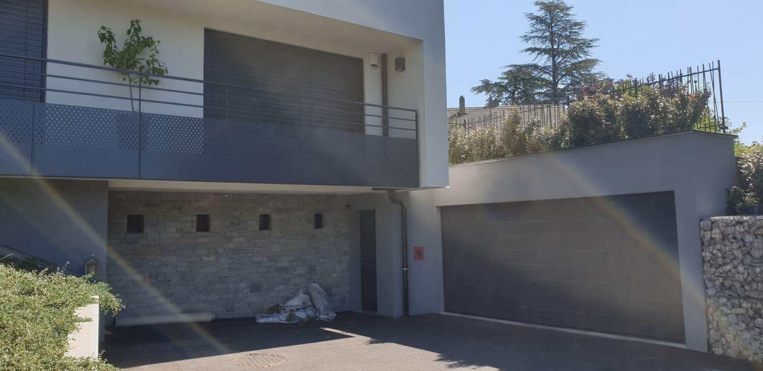 Charpentier installant un bardage en bois sur l'extérieur d'une maison.